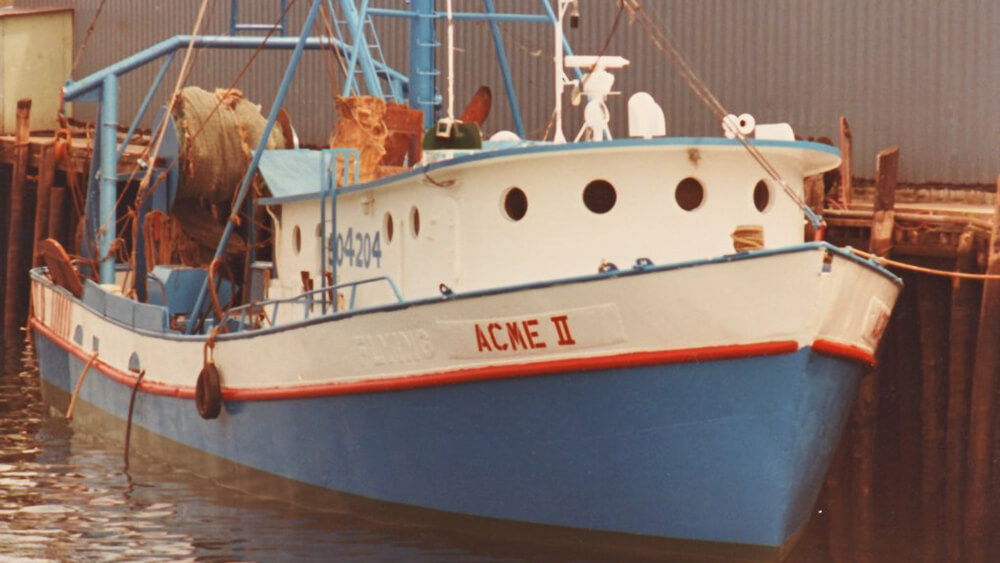 A small blue and white ship at a dock