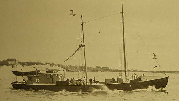 An old black and white photo of a small ship on the water