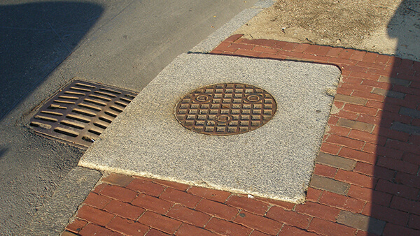 A manhole cover with granite around it