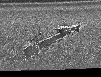 A black and white scan of the seafloor revieling a shipwreck