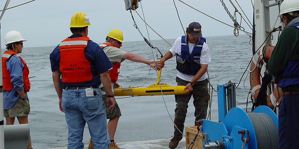 a side scan sonar being deployed off of a ship