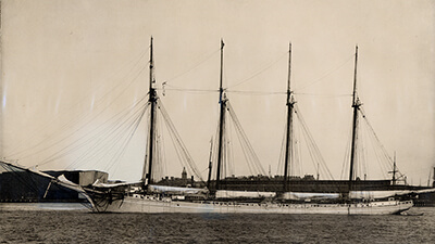 A black and white photo of a 4 masted ship