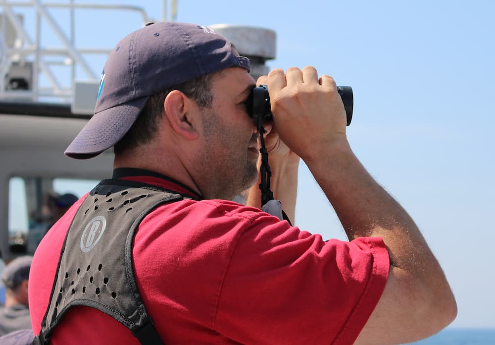 A man using bonoculars to whale watch