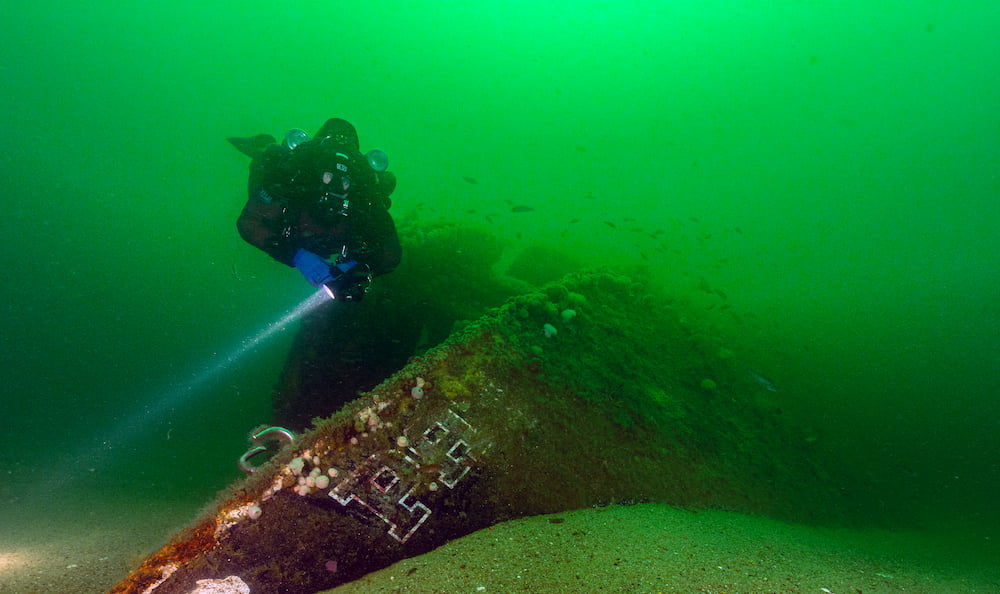 A diver swimming by the shipwreck of Patriot